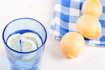 Wall Mural - water with lemon and mint in blue glass on the table top view