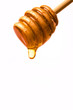 Honey dripping from a wooden honey dipper isolated on white