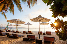 Sun Umbrellas And Beach Chairs On Tropical Beach