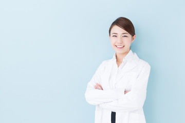 Wall Mural - young asian doctor on blue background