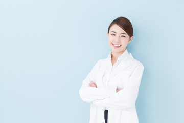 Wall Mural - young asian doctor on blue background