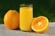 szklanka smacznego soku pomarańczowego i pomarańcze na stole