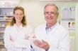 © WavebreakMediaMicro - Pharmacist and his colleague with arms crossed behind