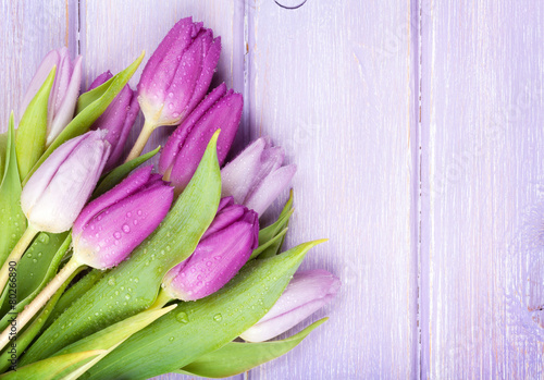 Fototapeta do kuchni Purple tulips bouquet over wooden table