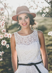 Wall Mural - Portrait of young woman in the flowered garden in the spring tim