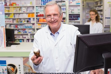 Pharmacist holding medicines looking at camera