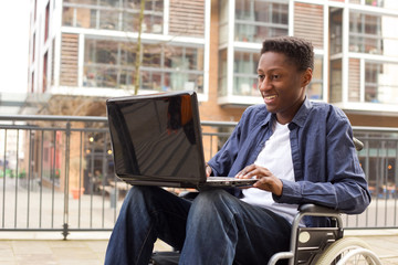 a young wheelchair user working on a laptop.