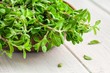 raw green herb marjoram in the bowl on a white  wooden table