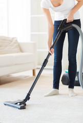 Wall Mural - close up of woman with vacuum cleaner at home