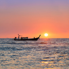 Wall Mural - Traditional thai longtail boat against sunset above ocean, Thail