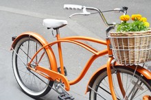 Orange Bicycle With Flower Basket.