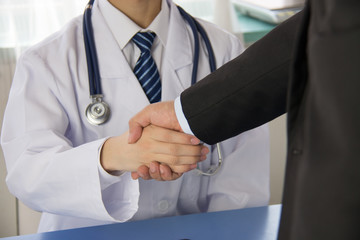 Wall Mural - Doctor and businessman shaking hands