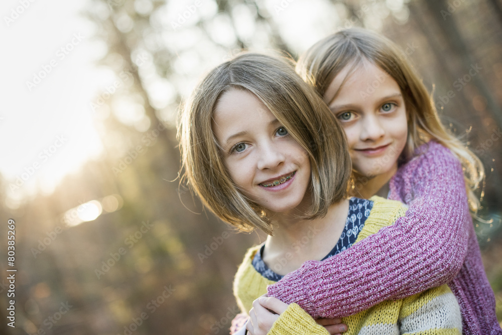 Two smiling girls in a forest, hugging each other. Stock Photo | Adobe ...