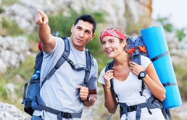 summer. hiking people. a couple of hikers pointing looking at