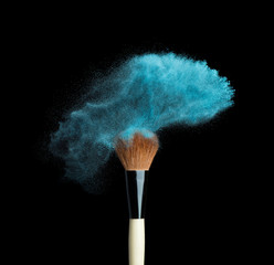 Isolated blue make-up powder with brush on black background