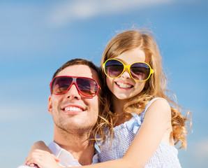 Sticker - happy father and child in sunglasses over blue sky