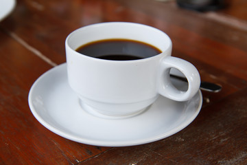 Black coffee in a white cup on the table.