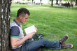 © lexmomot - Group of Teenage Students at Park with Computer and Books