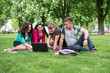 © lexmomot - Group of Teenage Students at Park with Computer and Books