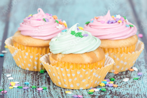 Fotografie, Obraz Pastel cupcakes with sprinkles on blue vintage background
