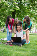 © lexmomot - Group of Teenage Students at Park with Computer and Books