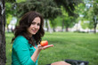 © lexmomot - Woman eating an apple outdoors