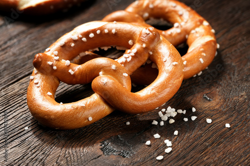 Cuadros en Lienzo Fresh pretzels with sea salt close-up on dark board background