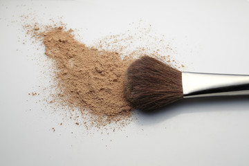 Makeup Brush with beige loose Face Powder on white background