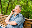 © kostyha - old man on a park bench talking on the phone