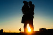 Couple silhouette is kissing at the sunset on the beach