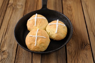 Wall Mural - Hot cross buns in cast iron skillet on wooden background