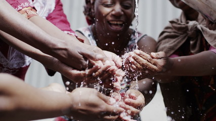 stream of fresh water and the hands of people from a poor community