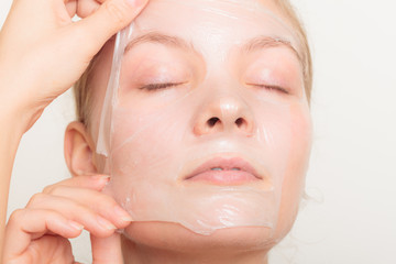 girl removing facial peel off mask