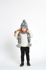 Wall Mural - Beautiful blond girl playing in the winter warm hat and scarf on