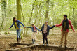 © Mint Images - Beech woods in Autumn. A family of four people, two adults and two children.