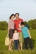 © Mint Images - A family, two parents and two children outdoors in the summer having a picnic.