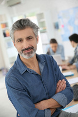 Canvas Print - Portrait of mature teacher sitting in class