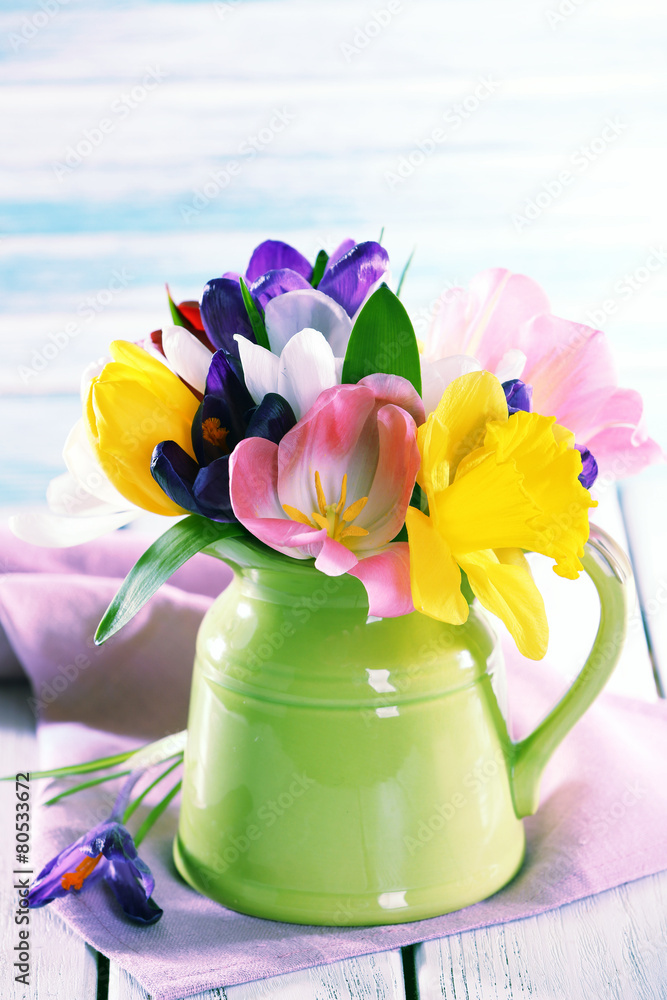Beautiful spring flowers on wooden table on blue background
