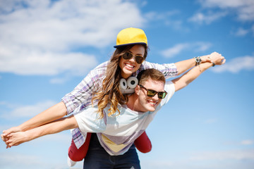 smiling teenagers in sunglasses having fun outside