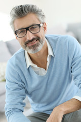 Canvas Print - Smiling mature man with grey hair wearing eyeglasses