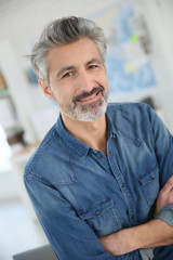 Wall Mural - Portrait of smiling mature teacher in class