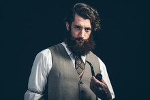 Stylish Man With A Beard Smoking A Pipe