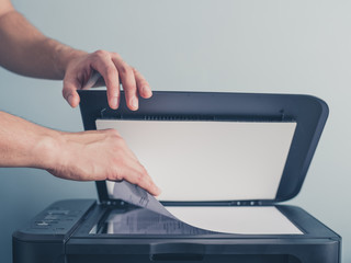 Hands of a man copying a piece of paper