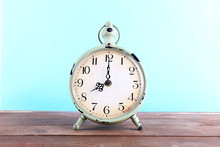 Alarm Clock On Wooden Table On Blue Background