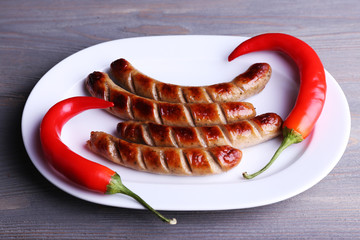 Sticker - Grilled sausages on plate with chili pepper on table close up