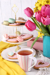 Wall Mural - Composition of spring flowers, tea and cookies on table