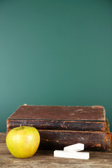 Poster - Old books, apple and chalk on blackboard background