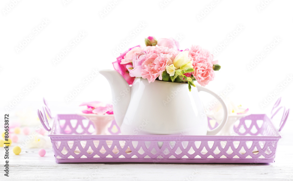 Beautiful spring flowers in teapot isolated on white