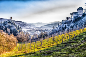 Poster - Medieval  Fortress and clock tower among hills in the fog