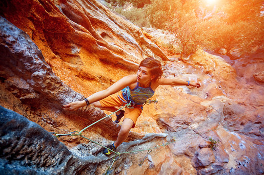 Rock climber climbing up a cliff
